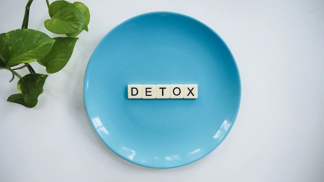 Niebieski talerz z literami DETOX i zielonym liściem, symbolizujący detoksykację i zdrowie